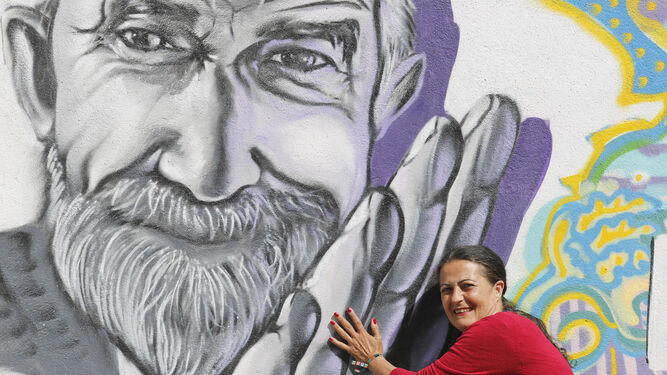 Concha Martínez, el pasado jueves, junto al grafiti de Miguel, a quien considera el Vicente Ferrer del barrio.