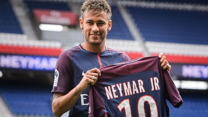 Neymar posa con su nueva camiseta sobre el césped del Parque de los Príncipes.