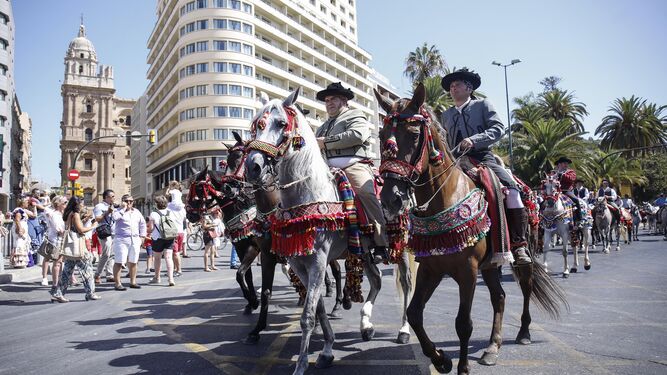 Los jinetes se dirigen a la plaza de Marqués de Larios para presenciar la izada a la bandera de Málaga.