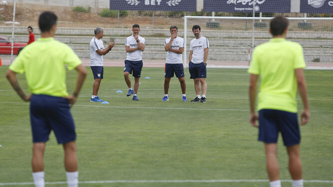 Los técnicos del Málaga contemplan un entrenamiento del equipo.