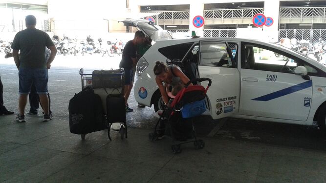 Un taxi carga a una pareja con un bebé.