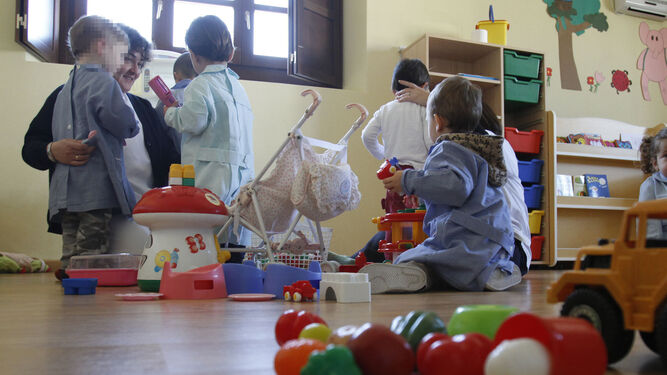 Niños con su cuidadora en un centro de educación infantil de primer ciclo.
