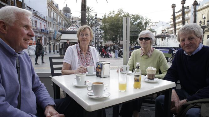 Turistas mayores conversan en una terraza.
