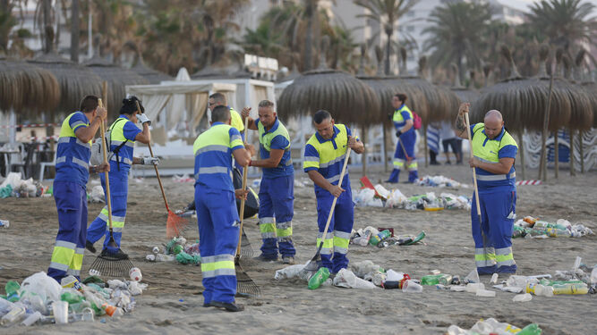 Trabajadores de Limasa limpian una playa de Málaga.