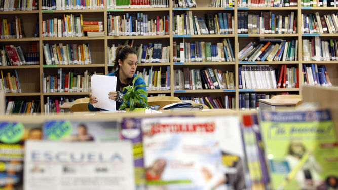 Una joven estudia en una biblioteca.