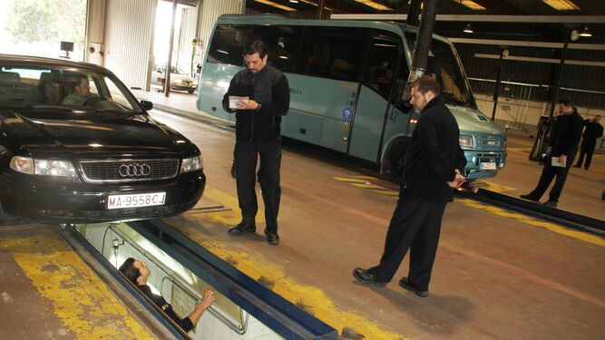 Unos técnicos inspeccionan un coche en un centro de la ITV en Málaga.