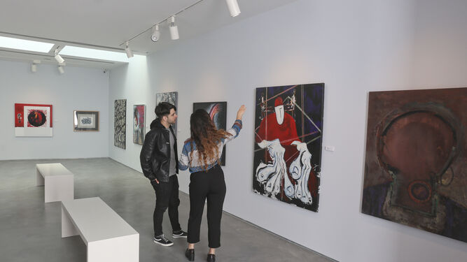Jovénes visitantes conversan sobre los cuadros de la exposición.