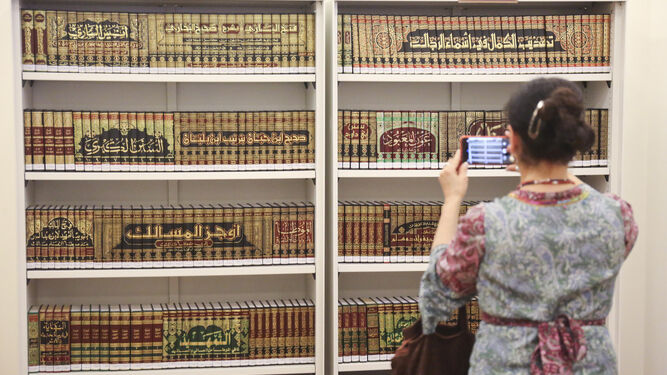 Una mujer saca fotos a los libros de la biblioteca.