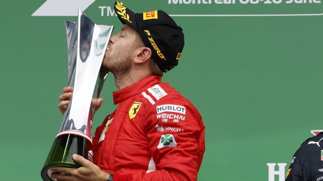 Vettel celebra su triunfo besando el trofeo.