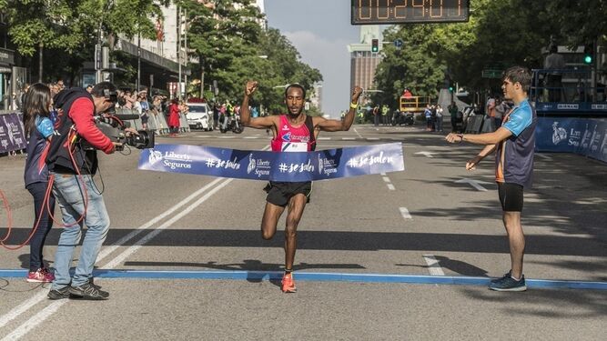 Gizaw Bekele levanta los brazos tras cruzar la línea de meta en el medio maratón de Madrid.