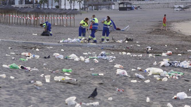 Operarios de Limasa recogen la basura tras la celebración de la Noche de San Juan.
