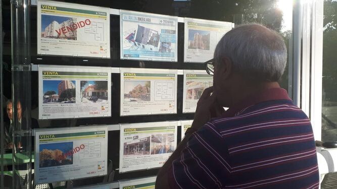 Un hombre observa el escaparate de una inmobiliaria en Málaga.