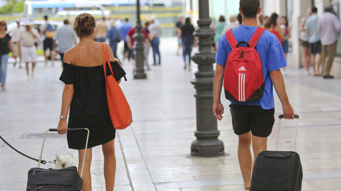 Turistas arrastran maletas por una calle de Málaga