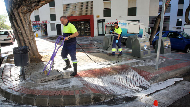 Operarios de limpieza durante el baldeo de calles en Marbella.