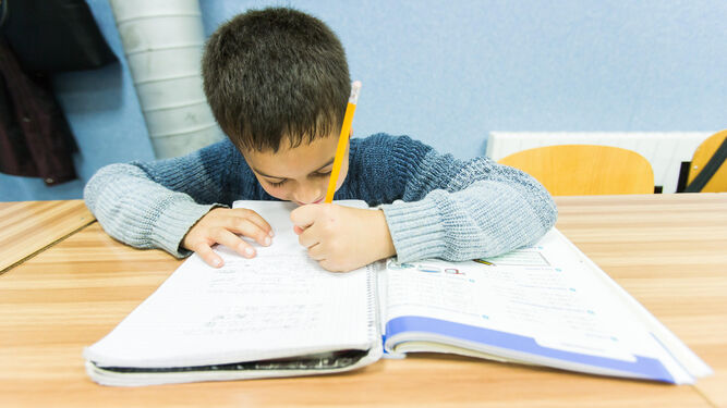 Un niño haciendo los deberes en clase.