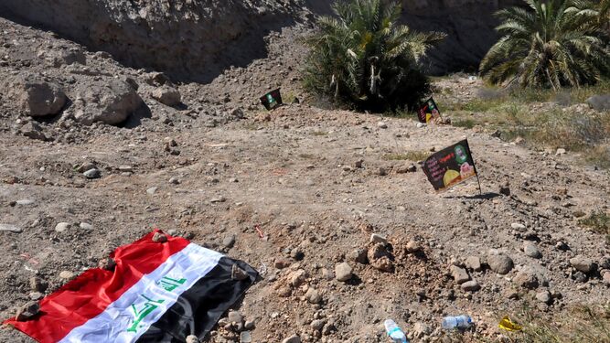 Bandera iraquí en una de las fosas halladas y que fueron usadas por el Estado Islámico