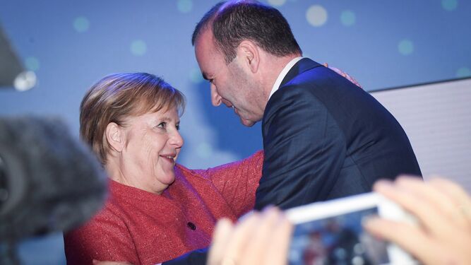 Weber es felicitado por Merkel en Helsinki.