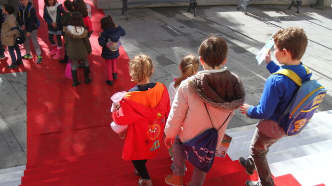 Un grupo de niños sale de la Casa Colón tras asistir a una proyección.