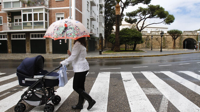 Una mujer camina con su bebé por la calle