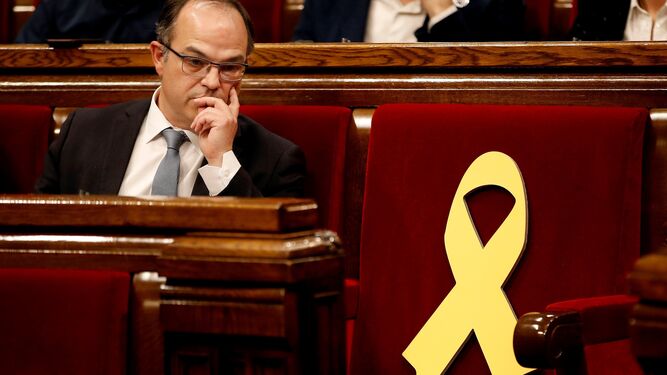 El ex 'conseller' Jordi  Turull , junto al escaño vacio del diputado encarcelado Jordi  Sánchez, el pasado 22 de marzo en el Parlamento catalán.