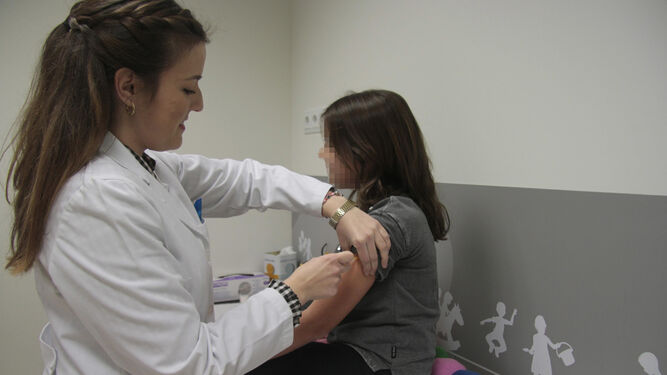 Una enfermera vacuna a una niña.