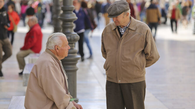 Dos jubilados conversan en la calle Larios en una imagen de archivo