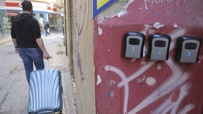 Un turista se va con la maleta tras dejar la llave en estas cajas en la pared