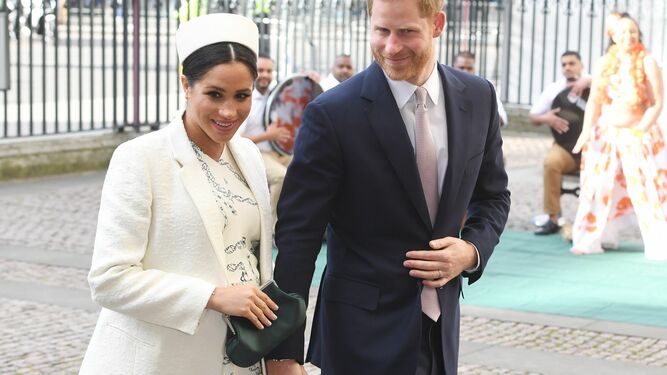 Meghan, con vestido de Victoria Beckham y abrigo blanco, junto a Enrique a su llegada a la Abadía de Westminster.