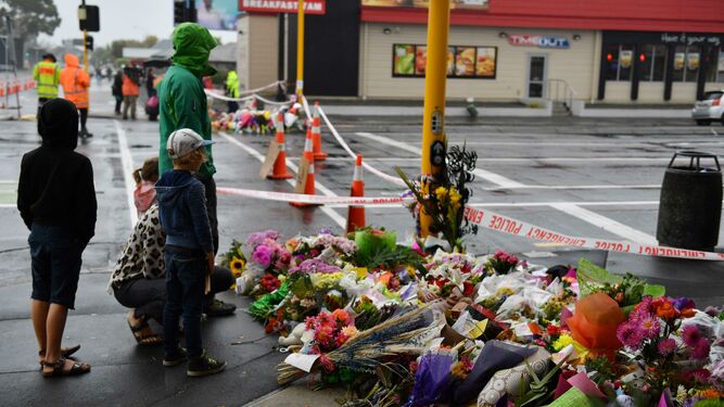 Varios ciudadanos ofrecen flores en memoria de las víctimas del atentado, cerca de la mezquita de Linwood en Christchurch.