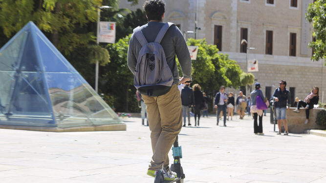 Un usuario circula en un patinete eléctrico por la calle Alcazabilla.