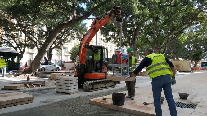 Obreros colocan una pieza del nuevo pavimento en el lateral sur de la Alameda.