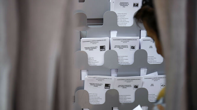 Una persona coge un voto en un colegio electoral