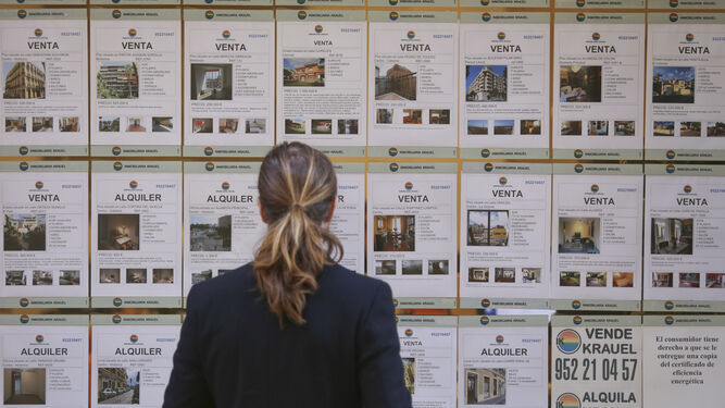 Una mujer observa el escaparate de una inmobiliaria