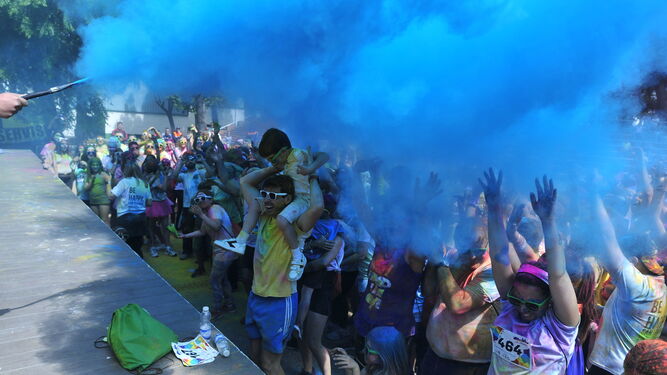 Lluvia de polvos de color azul para los participantes de la Carrera de la Felicidad.
