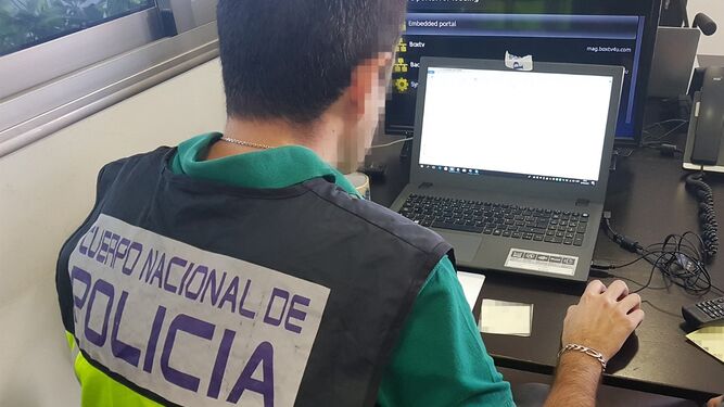 Un policía nacional frente a un ordenador