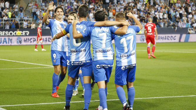 Los jugadores del Málaga celebran el gol de Leschuk.