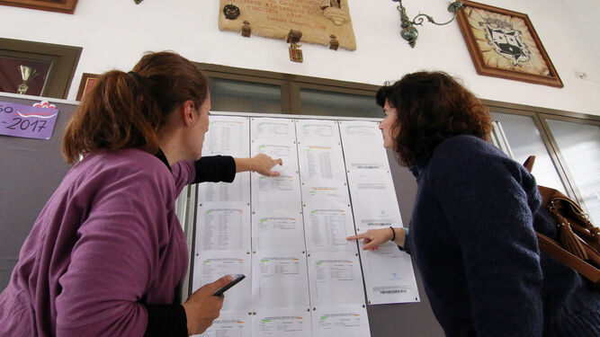 Dos madres consultan los listados en un colegios.