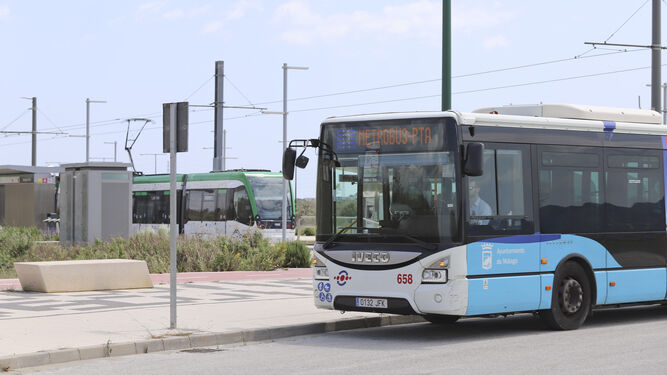 Un autobús pasa con el Metro por detrás en Málaga.