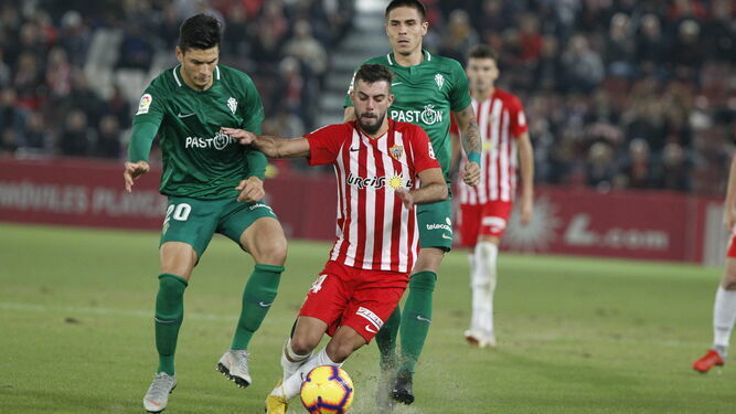 Luis Rioja protegiendo el balón frente a los jugadores del Sporting