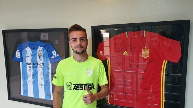 Ismael Casas con las camisetas del Málaga y la selección.