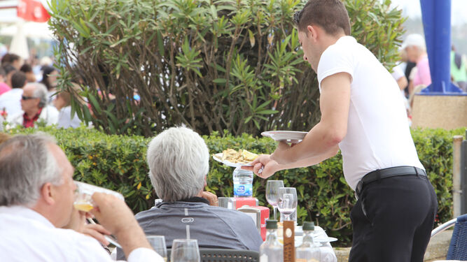 Un camarero atiende a una mesa en una terraza