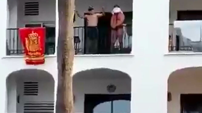La víctima, maniatada y ensangrentada, junto a su agresor en el balcón.