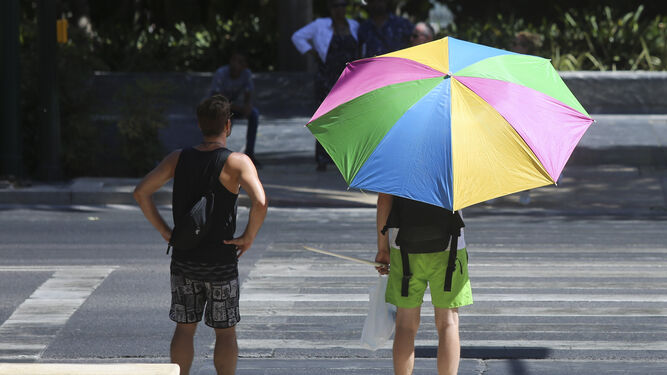 Dos turistas se protegen del sol este martes en la Málaga capital.