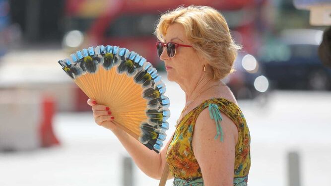 Una mujer combate el calor con un abanico en la capital.