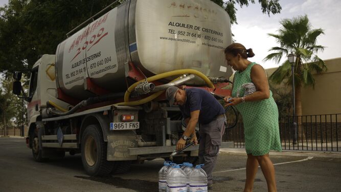 Un camión cisterna abastece a una vecina de Fuente de Piedra de agua potable.