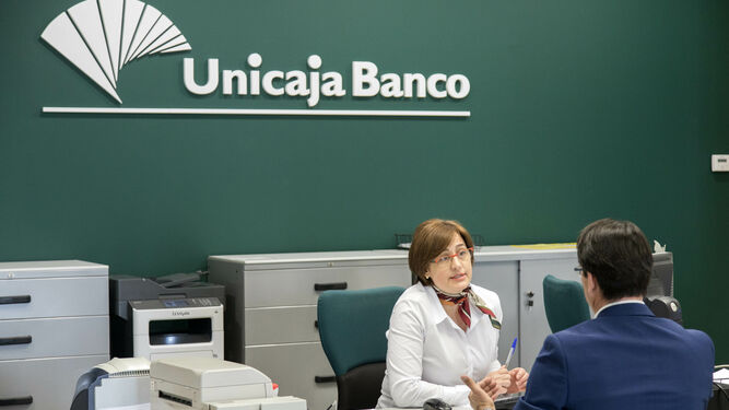 Una empleada de Unicaja Banco conversa con un cliente.