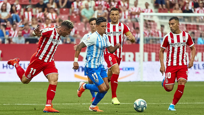 Renato Santos conduce el esférico rodeado por tres jugadores del Girona en el último enfrentamiento ante los catalanes.