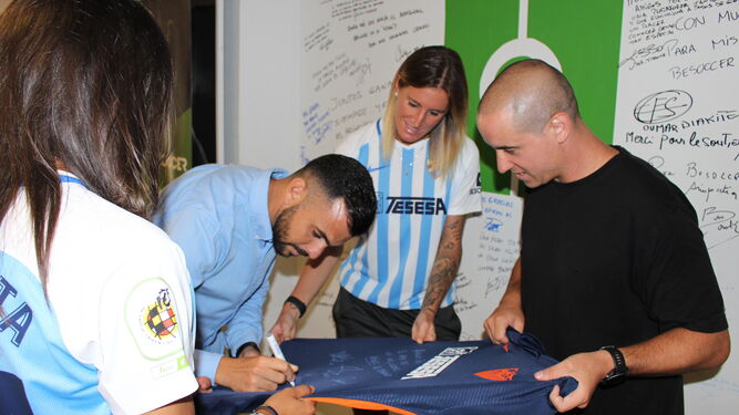 José Herrera firmando la camiseta del Málaga.