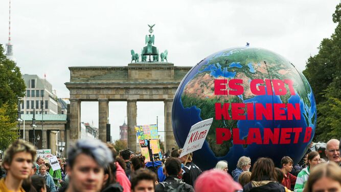 Decenas de jóvenes manifestantes sostienen un globo gigante con la inscripción "No hay planeta B" en Berlín.