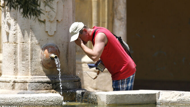 Un turista se refresca del intenso calor.